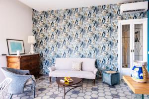 a living room with a couch and a blue and white wallpaper at Casa Duca - Marina di Ragusa in Marina di Ragusa