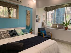 a bedroom with a bed and a blue wall at Mon Desire 1, Perry Cross Rd, Bandra West by Connekt Homes in Mumbai