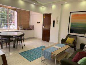 a living room with a table and a dining room at Mon Desire 1, Perry Cross Rd, Bandra West by Connekt Homes in Mumbai