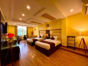 Habitación de hotel con 2 camas y escritorio en Rio Classic, Top Rated & Most Awarded Property in Haridwar, en Haridwar