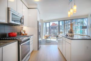 a kitchen with white cabinets and a large window at Rincon Hill 1BR w AC Gym nr Bay Bridge SFO-156 in San Francisco