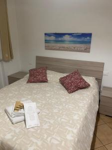 - un lit avec deux oreillers et un livre dans l'établissement "Coccole nel borgo" 2min to outlet apartment with terrace, à Serravalle Scrivia 13 autres photos