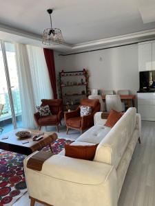 a living room with a white couch and chairs at Mersin'in en lüks ve en güzel 2+1 evi in Mersin