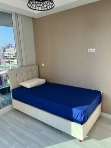 een bed in een kamer met een blauw matras en een raam bij Mersin'in en lüks ve en güzel 2+1 evi in Mersin