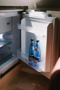 two bottles of soda sitting inside of an open refrigerator at Szklany Przystanek in Kościerzyna
