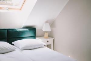 um quarto com uma cama com uma cabeceira verde e um candeeiro em Szklany Przystanek em Kościerzyna