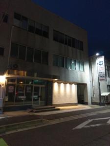 um edifício com uma placa à frente à noite em 令和院 Leiwa Inn em Tottori
