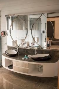 a bathroom with two sinks and a large mirror at W Goa in Vagator