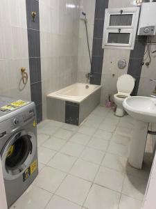 a bathroom with a washing machine and a sink at شقه in 6th Of October