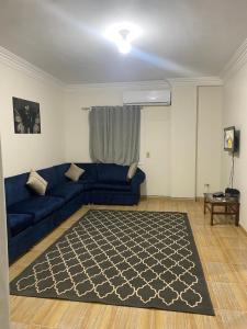 a living room with a blue couch and a rug at شقه in 6th Of October