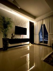 un soggiorno con TV e pianta in vaso di Eiffel Tower Apartment a Rawalpindi