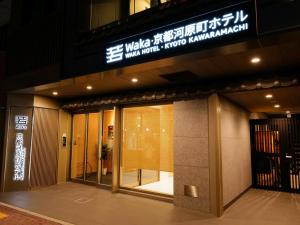 une entrée à un bâtiment avec un panneau sur celui-ci dans l'établissement 若 京都河原町ホテル Waka Kyoto Kawaramachi Hotel, à Kyoto
