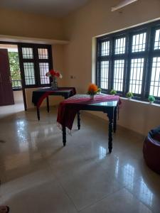 a room with two tables with flowers on it at Beyond Home in Kozhikode