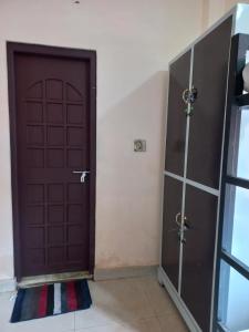 Brązowe drzwi w pokoju z podłogą wyłożoną kafelkami w obiekcie Beyond Home w mieście Kozhikode