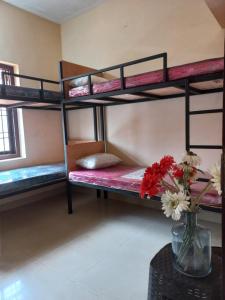 Pokój z łóżkami piętrowymi i wazą kwiatów w obiekcie Beyond Home w mieście Kozhikode