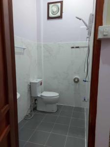 a white bathroom with a toilet and a shower at Inthavong Hotel/Guest House in Vang Vieng