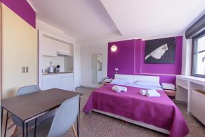 a purple bedroom with a bed and a table at Al Rayyan - Affittacamere in Montesano Salentino