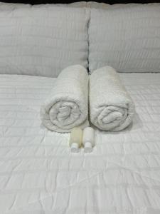 Una cama con toallas y dos tazas. en Home away from Home en East London