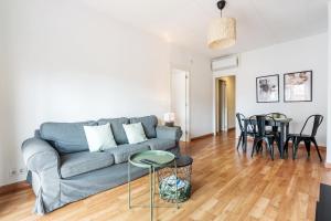 a living room with a couch and a table at Fridays Flats Heart Of The City Sunny With Iconic Terrace View in Barcelona