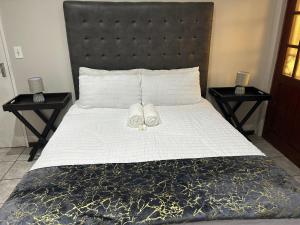 ein Bett mit zwei Handtüchern darauf mit zwei Nachttischen in der Unterkunft Home away from Home in East London