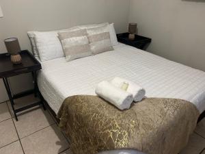 ein Schlafzimmer mit einem Bett mit zwei Handtüchern darauf in der Unterkunft Home away from Home in East London