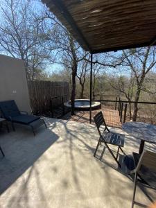 a patio with two chairs and a table and a bench at Terrapin Studio in Marloth Park
