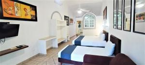 um quarto de hotel com duas camas e uma televisão em Tulipanes Cancun em Cancún