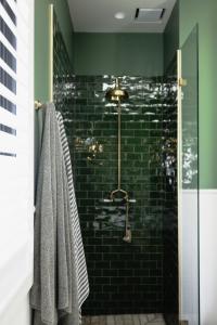 uma casa de banho com um chuveiro com azulejos pretos em Taylor's of Berry em Berry