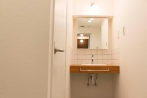 uma casa de banho com um lavatório e um espelho em Florish21 em Tóquio