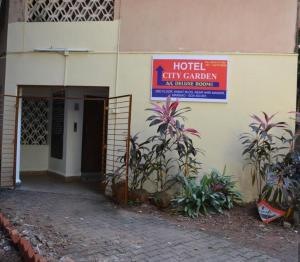 a hotel entrance with a sign on the side of a building at Hotel City Garden in Madgaon