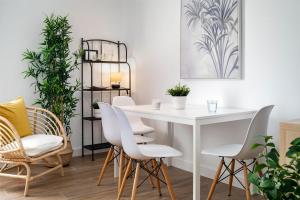 a dining room with a white table and chairs at Magno Apartments Miño in Seville