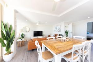 uma sala de estar com uma mesa e um sofá em Beaches International em Forster