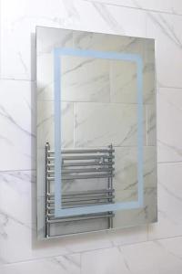 einen Spiegel an einer weißen Wand mit einem Fenster in der Unterkunft Exclusive 8beds 2bath Luxury Contractors Delight! in Southampton