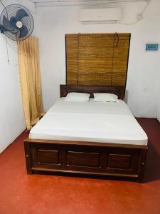 Bett in einem Zimmer mit Ventilator in der Unterkunft Thanamal-villa in Tanamalwila
