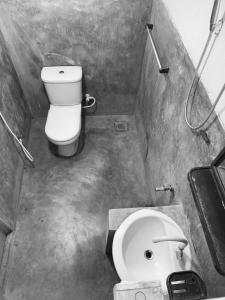 a small bathroom with a toilet and a sink at Thanamal-villa in Tanamalwila