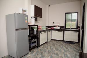 a kitchen with white cabinets and a refrigerator at Pool Villa at Salak 