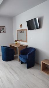 ヴァウブジフにあるNoclegi Wałbrzych - Pokoje Konradのテーブル、椅子2脚、鏡が備わる客室です。