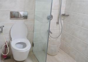 a bathroom with a toilet and a glass shower at Bentley Hotel, Marine Drive in Mumbai