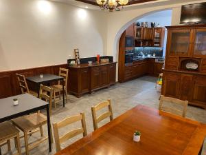 a dining room with tables and chairs and a kitchen at Penzion Mořina in Mořina