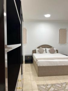 a bedroom with a bed and a television in it at غزالي للوحدات السكنية in Al Madinah