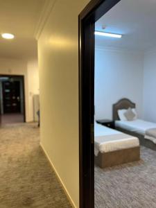 een spiegel in een kamer met een bed en een bank bij غزالي للوحدات السكنية in Al Madinah