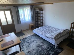 Schlafzimmer mit einem Bett, einem Schreibtisch und einem Fenster in der Unterkunft SKH Studio apartman in Praid