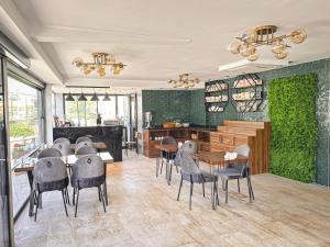 un restaurante con mesas y sillas y una pared verde en Çamlıca Hotel, en Pelitli