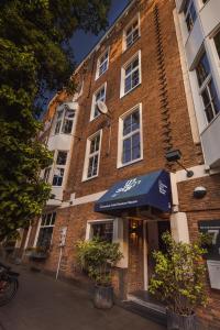 un bâtiment en briques avec un auvent bleu devant lui dans l'établissement Conscious Hotel Museum Square, à Amsterdam