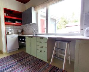 eine Küche mit einer Theke, einem Stuhl und einem Fenster in der Unterkunft Villa Mummola Kahden makuuhuoneen huoneisto lähellä jokea in Simpele