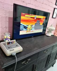 a tv on top of a black dresser with a video game at Dreamhouse in Melbourne