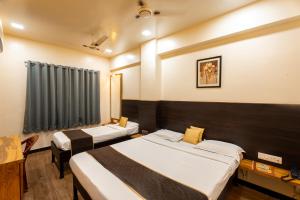 プネにあるHotel Ellora Parkのベッドが2つと窓があるホテルの部屋