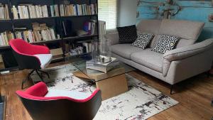 uma sala de estar com um sofá, uma mesa e cadeiras em Au bon endroit em Sevremont