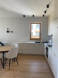 een keuken met een tafel en stoelen en een raam bij Apartament PORTO in Gdańsk