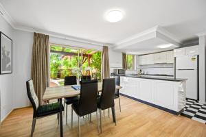 eine Küche und ein Esszimmer mit einem Tisch und Stühlen in der Unterkunft Marsfield 5 bed Townhouse near Macquarie Uni FreeP in Sydney